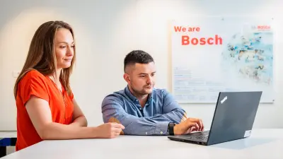 Grupa saradnika slavljenički podiže još jednog saradnika koji uživa u tome.